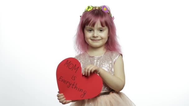 Девочка-принцесса держит красное бумажное сердце с текстом о матери. День матери — стоковое видео
