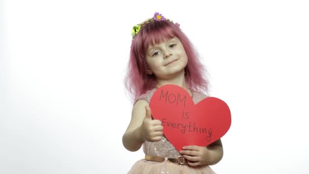 Niña princesa sostiene corazón de papel rojo con texto sobre la madre. Día de las madres — Vídeo de stock