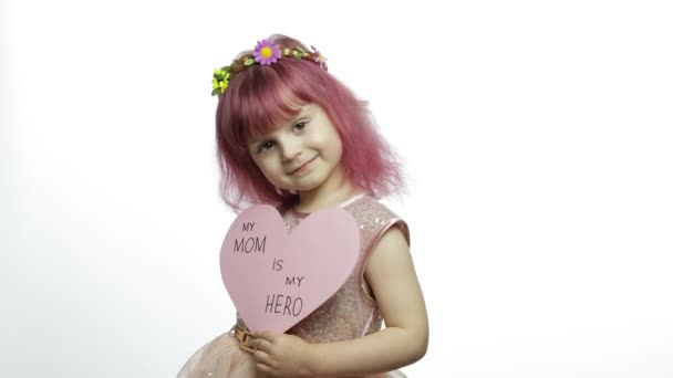 Niña princesa sostiene corazón de papel rosa con texto sobre la madre. Día de las madres — Vídeos de Stock