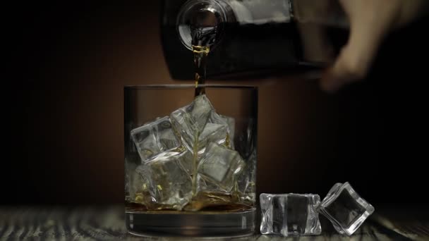 Whiskey, Cognac ins Glas gießen. Dunkler Hintergrund. Viel Alkohol getrunken — Stockvideo