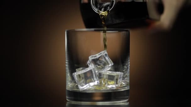 Häll whisky, konjak i glas. Mörk bakgrund. Häll upp alkoholhaltig dryck — Stockvideo