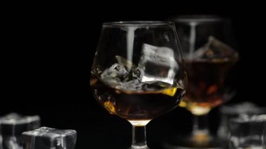 Buz küpleri bir bardak alkole, viski ve konyağa düştü. Yavaş çekim