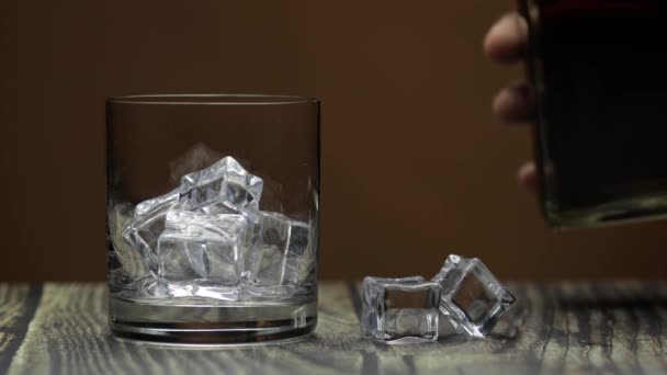 Whiskey-t, konyakot öntök az üvegbe. Sötét háttér. Alkoholtartalmú ital öntése — Stock videók