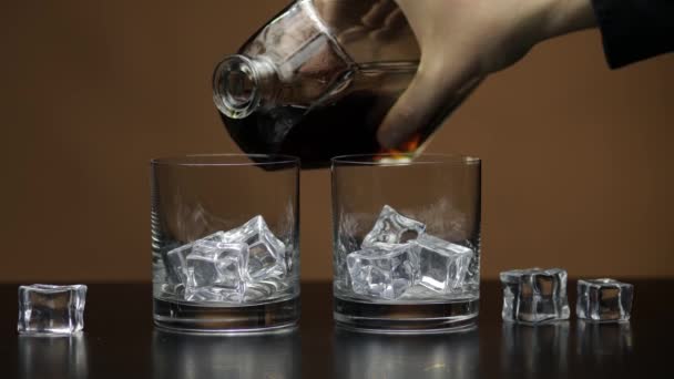 Whiskey, Cognac ins Glas gießen. Brauner Hintergrund. Viel Alkohol getrunken — Stockvideo