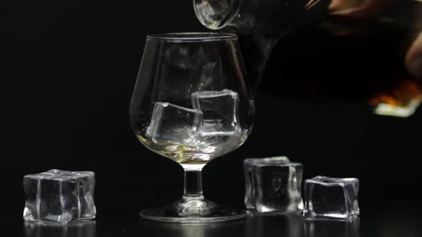 Verser du whisky, du cognac dans du verre. Fond noir. Verser la boisson alcoolisée — Video