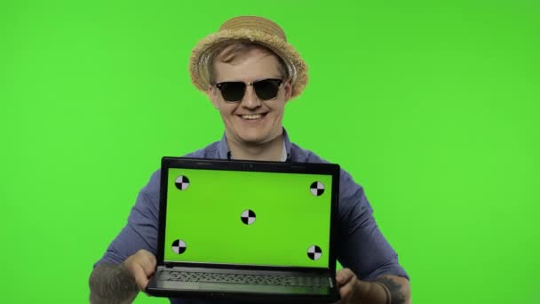 Портрет молодого туриста в сонцезахисних окулярах, що показує ноутбук. Клавіша Chroma — стокове відео
