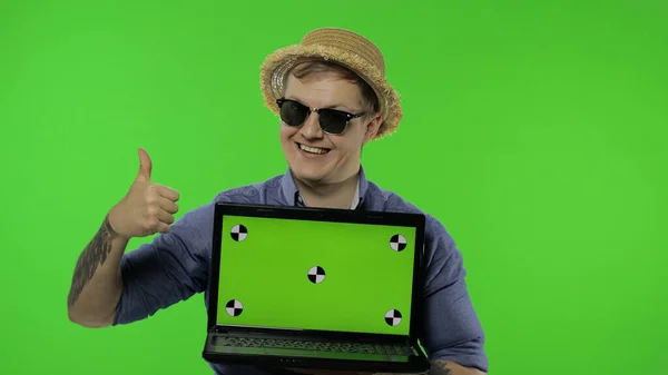 Portrait of man tourist in sunglasses showing laptop. Thumbs up. Chroma key — Stock Photo, Image