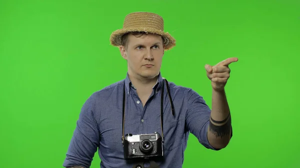 Portrait of young man tourist photographer pointing finger. Chroma key — Stock Photo, Image