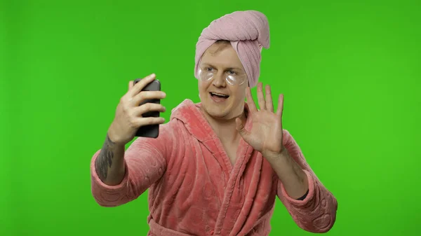 A fürdőköpenyes transzszexuális férfi portréja mobiltelefonnal videohíváshoz — Stock Fotó