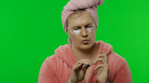 Homem transexual em roupão de banho com manchas oculares fazendo manicure. Chave Chroma — Fotografia de Stock