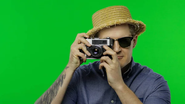 Портрет человека туристического фотографа, делающего фотографии на ретро-камеру. Ключ хрома — стоковое фото