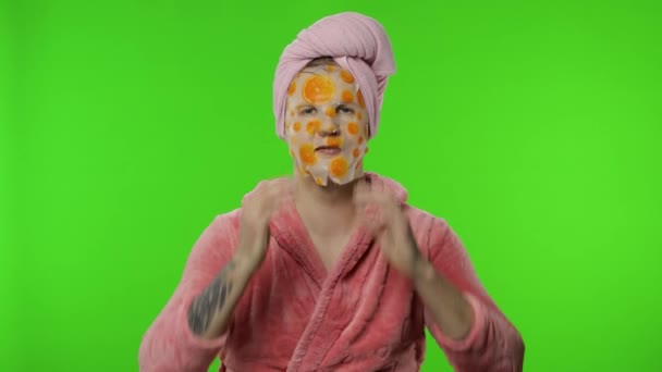 Homme transsexuel en peignoir avec masque facial regardant la caméra, souriant — Video
