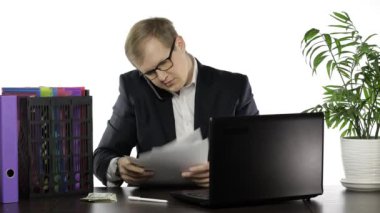 Ofiste çalışan bir iş adamı. Gazete okurken telefonda yüksek sesle konuşmak