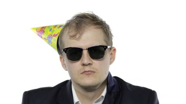 Şenlik şapkası ve güneş gözlükleriyle sarhoş genç bir iş adamı.