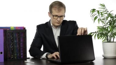 Ofiste çalışan bir iş adamı. Bir dizüstü bilgisayar açar ve faiziyle çalışmaya başlar