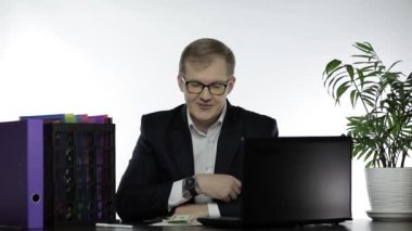 İş adamı kameraya işaret ediyor. Para ile övünüyor. Kutlamayı başarıyor.