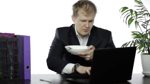 Disheveled businessman working in office having a lunch at the office desk — Stock Video