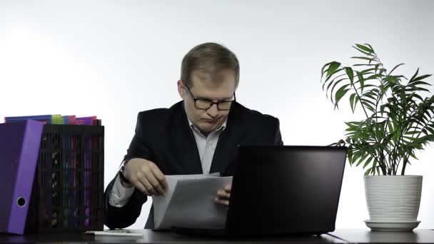 Businessman working in office. Reading papers at table and work on laptop — Stock Video