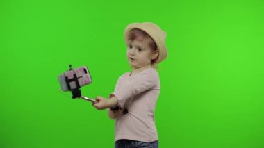 Kız çocuğu selfie çekiyor, cep telefonunda selfie çubuğu kullanıyor. Krom anahtar