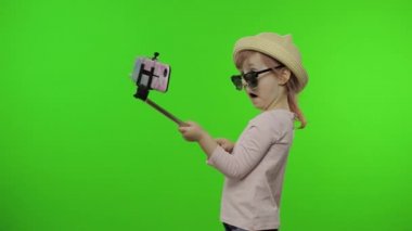 Kız çocuğu selfie çekiyor, cep telefonunda selfie çubuğu kullanıyor. Krom anahtar