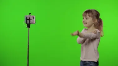 Kız çocuğu monopod kullanarak selfie vlog, blog, video çağrısı yapıyor.