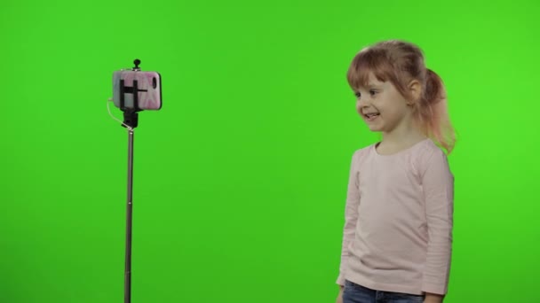 Fille enfant fait selfie vlog, blogging, appel vidéo sur téléphone mobile en utilisant monopode — Video