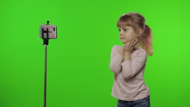 Fille enfant fait selfie vlog, blogging, appel vidéo sur téléphone mobile en utilisant monopode — Video