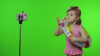 Kız çocuğu cep telefonundan selfie, blog, blog, video görüşmeleri yapıyor. Tatil Denizi