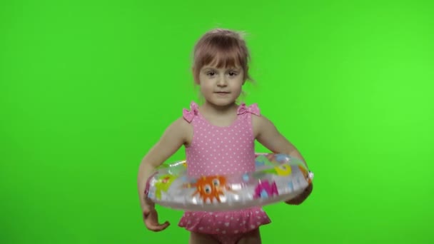 Yüzme yüzüğüyle yürüyen mayolu komik kız çocuğu surat yapıyor. Tatil — Stok video