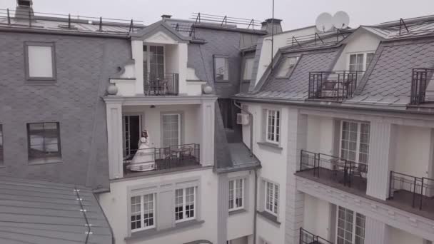 Mariée en robe de mariée sur le balcon de sa maison. Le matin du mariage. Vue aérienne — Video