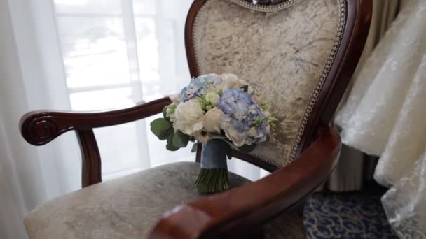 Boeket witte rozen en blauwe bloemen. Bruiloft boeket van de bruid op stoel — Stockvideo