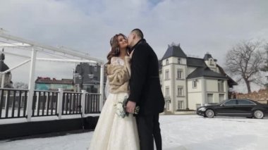 Yeni evliler. Beyaz damat gelini öpüyor. Düğün çifti. Mutlu bir aile. Kış