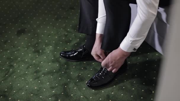 新郎の手の結婚式の日に彼の結婚式の靴を置く。結婚式日 — ストック動画