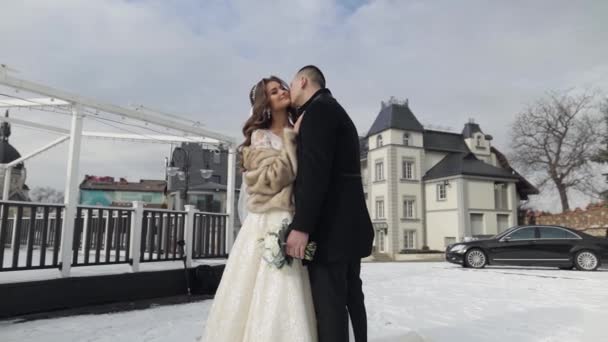 Les jeunes mariés. Le marié caucasien embrasse mariée. Un couple. Bonne famille. Hiver — Video