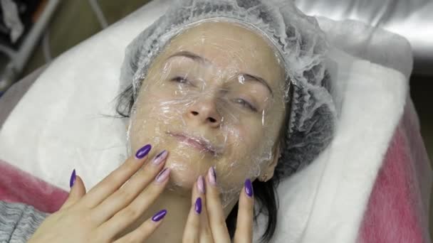 Portret van een vrouw in een schoonheidssalon. Meisje met masker op gezicht met zeepschuim — Stockvideo