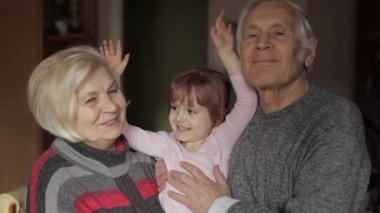 Gülümseyen aile büyükbaba, büyükanne ve torunu evde.