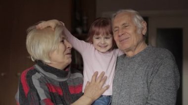 Gülümseyen aile büyükbaba, büyükanne ve torunu evde.