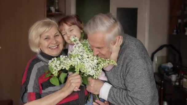 Lächelnder Familiengroßvater, Großmutter mit Enkelin zu Hause — Stockvideo