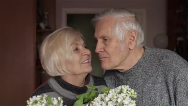 Mutlu bir büyükbaba ve büyükannenin portresi. Büyükanne büyükbabayı öpüyor. — Stok video