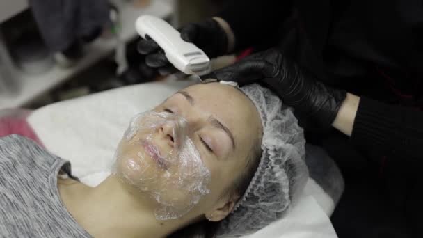 Cosmetologue faire nettoyage du visage par ultrasons sur le visage de la femme dans le salon de la clinique de beauté — Video