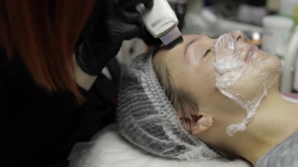 Kosmetolog gör ultraljud ansikte rengöring på kvinna ansikte i skönhetsklinik salong salong — Stockvideo