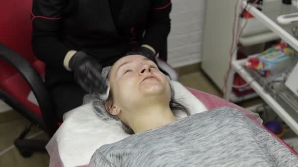 Cosmetoloog schoon clien vrouw gezicht van hydraterende masker in schoonheidssalon — Stockvideo