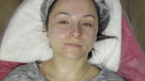 Portrait de femme dans un salon de beauté. Fille avec masque hydratant sur le visage — Video