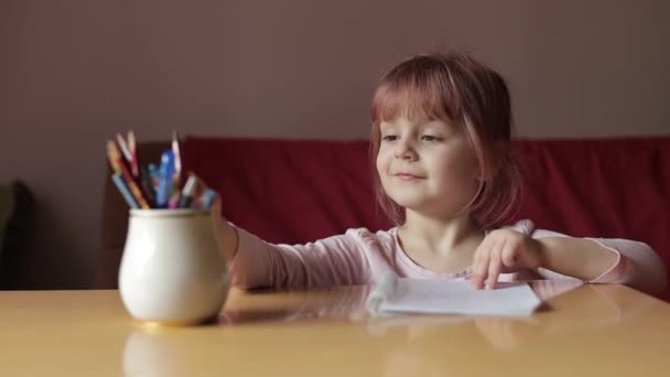 Мила дівчинка художник вивчає малюнок з ручкою і олівцями вдома — стокове відео