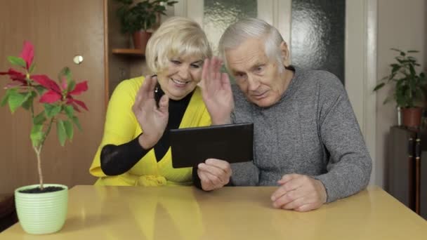 Vrij volwassen senior paar grootouders het maken van video gesprek met tablet thuis — Stockvideo