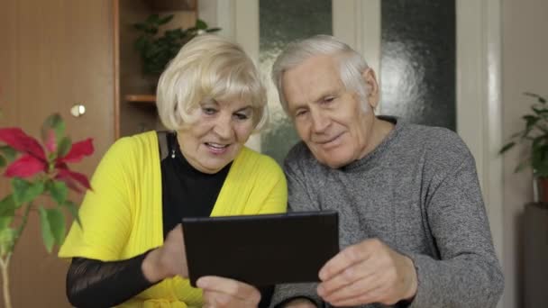 Vrij volwassen senior paar grootouders het maken van video gesprek met tablet thuis — Stockvideo