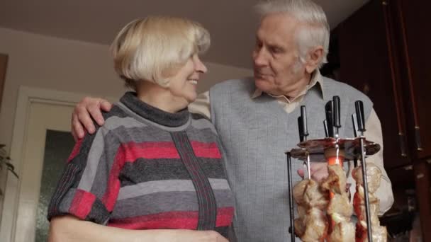 Mutlu yaşlı büyükanne ve büyükbaba çiftimiz evde ızgarada barbekü pişiriyor. — Stok video