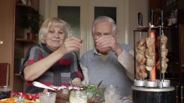 Feliz pareja de abuelos celebra cocinar barbacoa en la parrilla eléctrica en casa — Vídeos de Stock