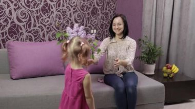 Küçük kızım annesini bir demet leylak çiçeğiyle tebrik ediyor.