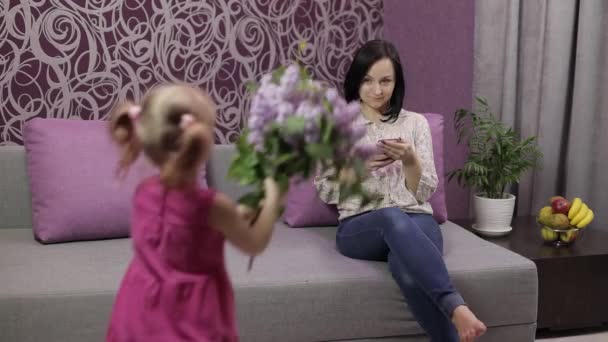 La hija pequeña felicita a la mamá con el ramo de las flores. Movimiento lento — Vídeos de Stock